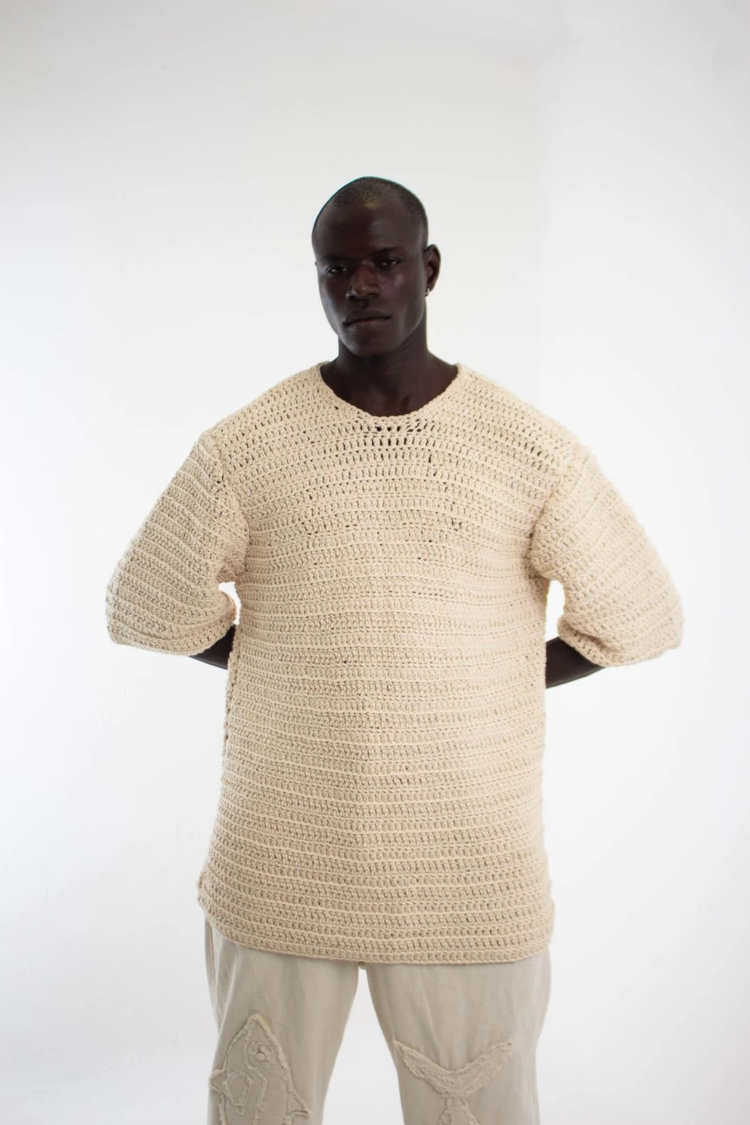 Cream short-sleeve open-knit top shown on a plain background.