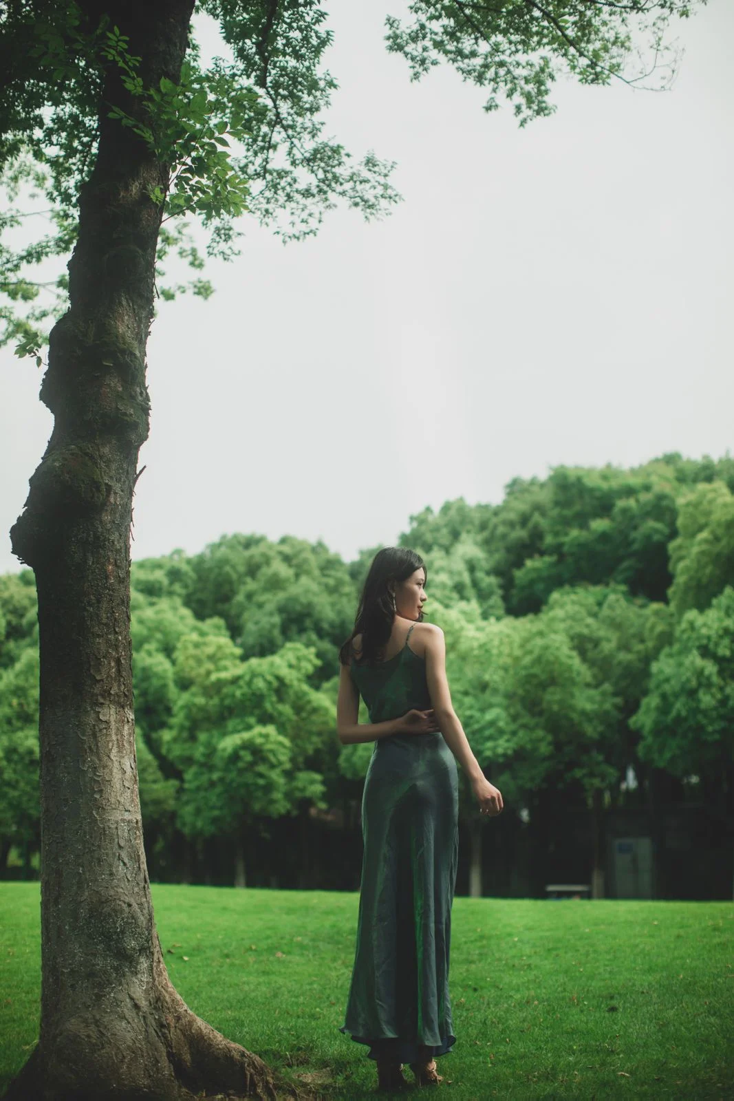 Green/emerald slim long dress photographed outdoors from the back and side.