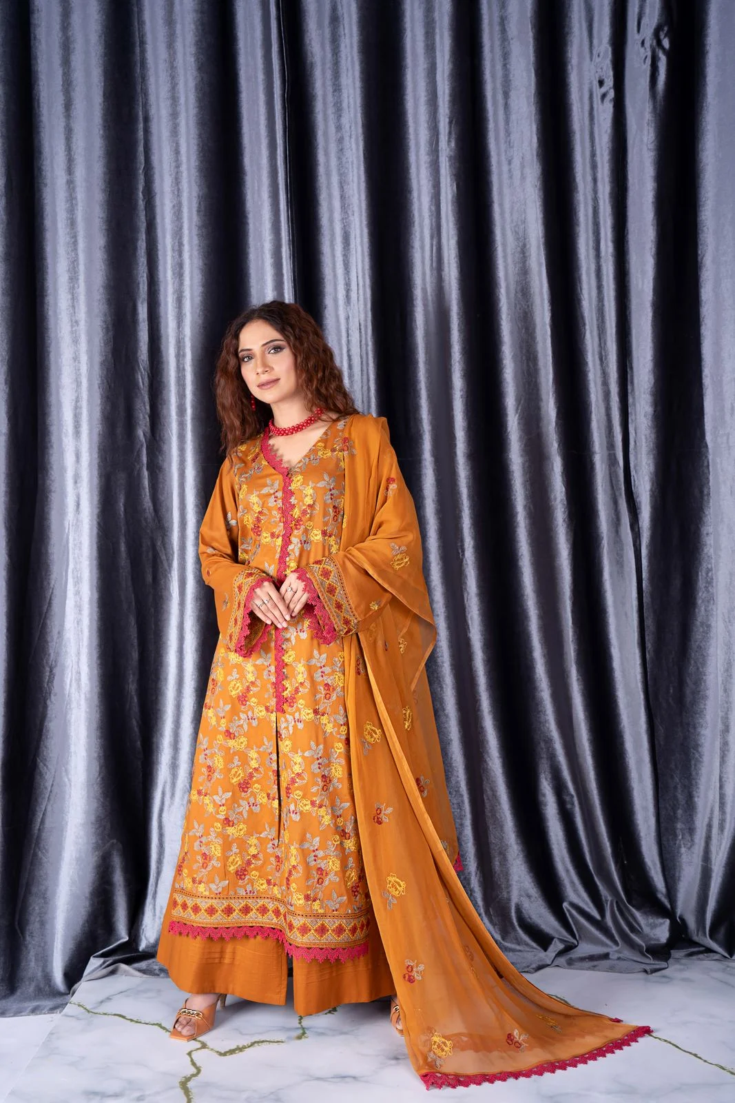 Ochre embellished long kurta shown with matching trousers and a dupatta.