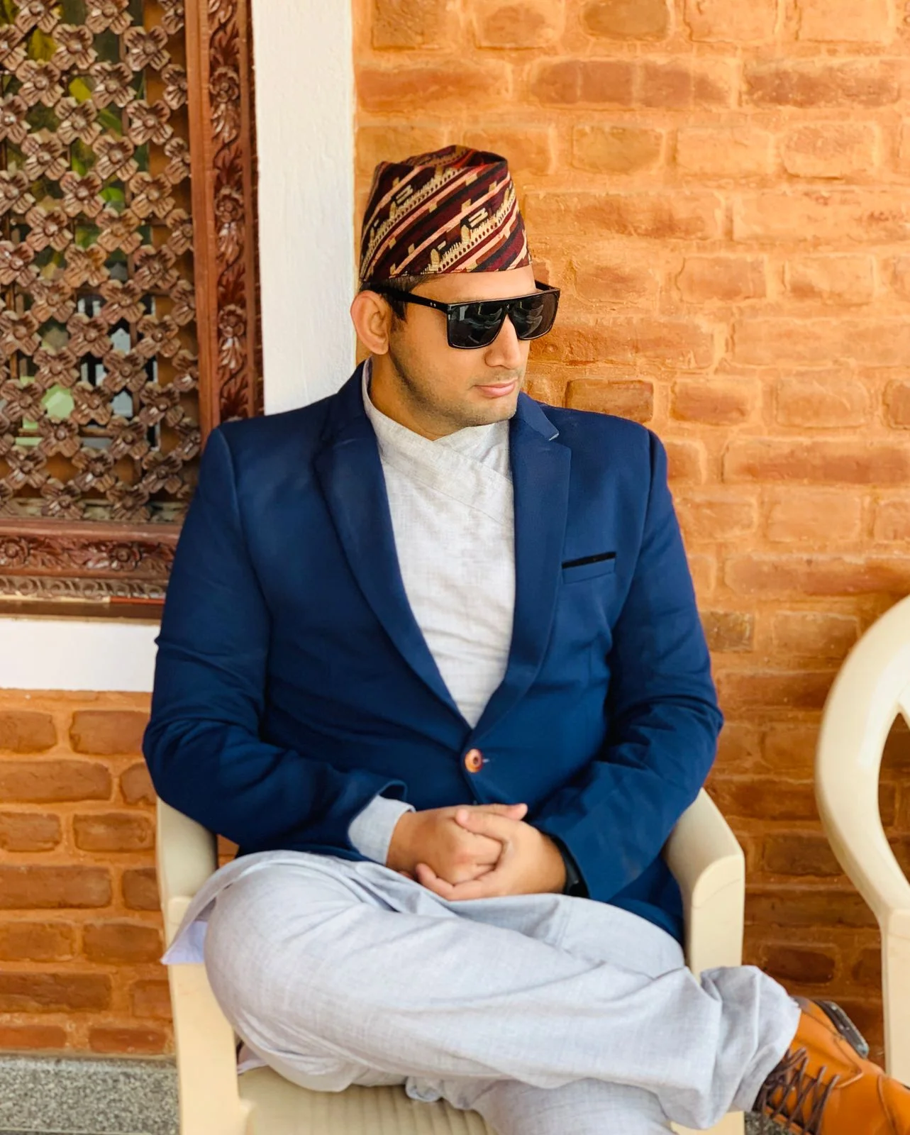 Ivory/light-grey daura and trousers shown seated with a navy blazer.